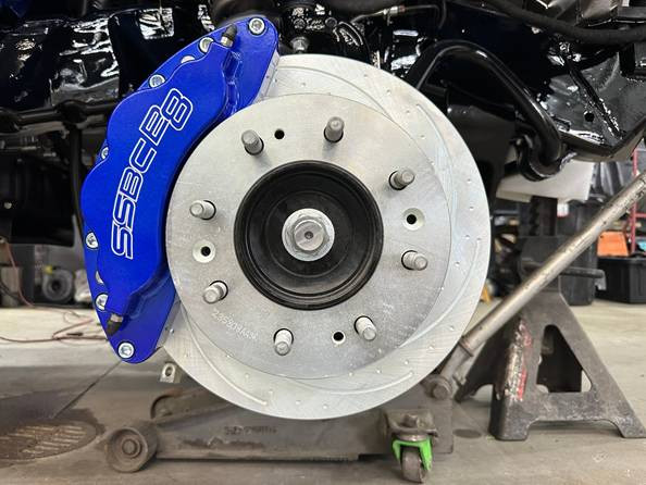 Blue SSBC B8 8-piston caliper mounted over a drilled and slotted rotor on the truck