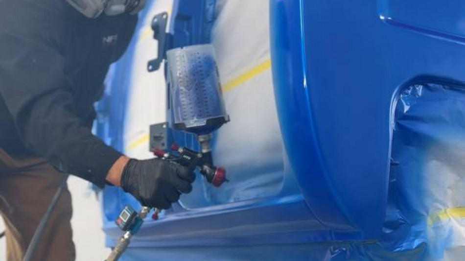 NFI Empire painter in respirator spraying blue paint on Project REBORN-001